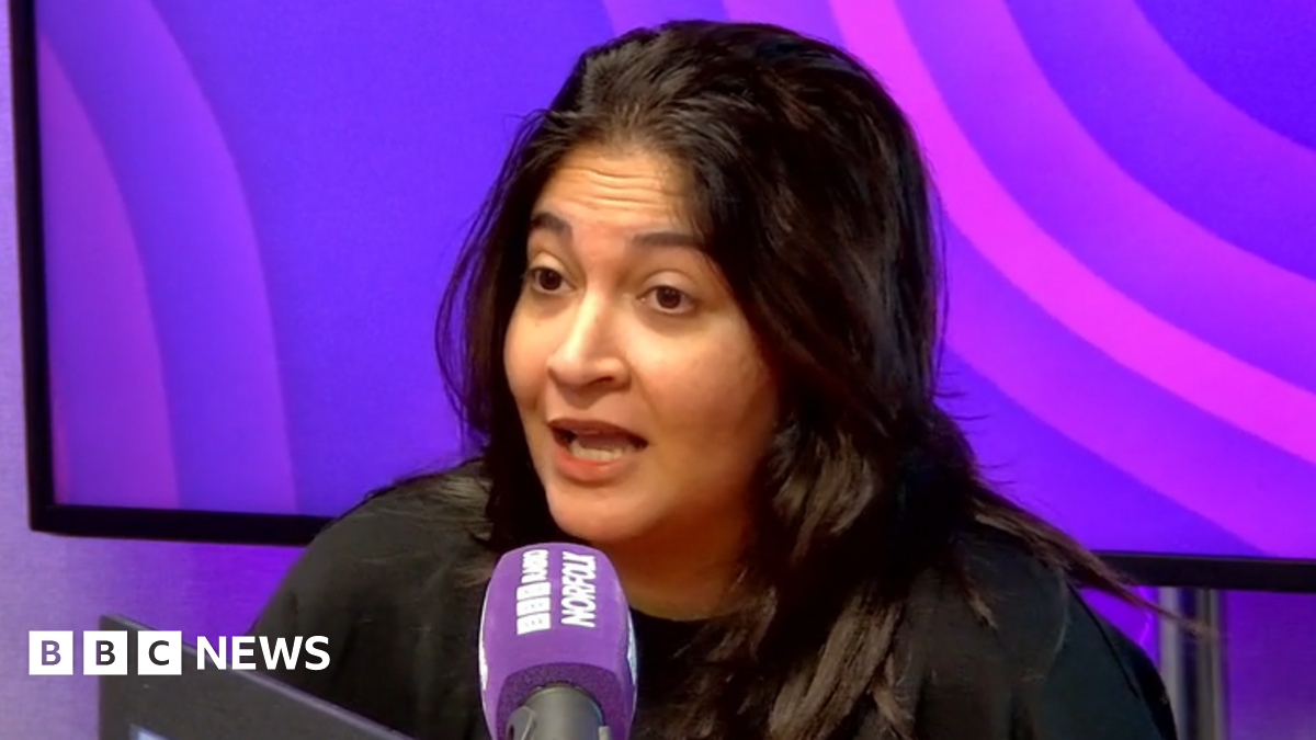 A resident walks with a shovel along a mud-covered road in Hualien on September 24, 2025, following the bursting of a barrier lake during the passing of Super Typhoon Ragasa.