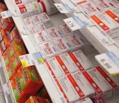 Acetaminophen and other pain relievers on a drugstore shelf.