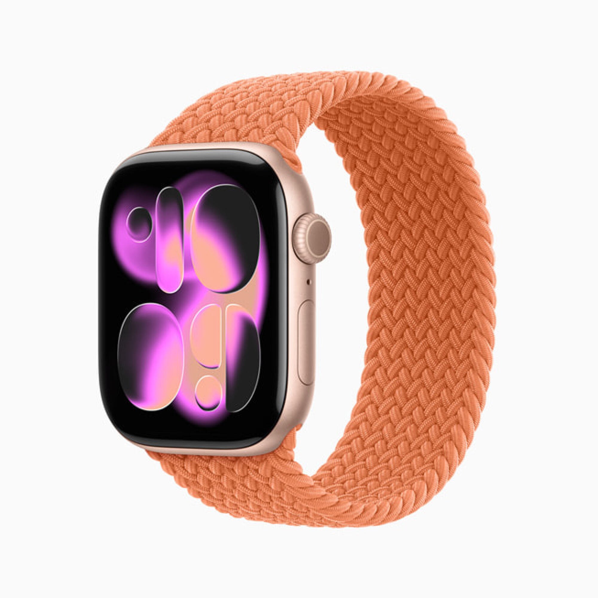 An Apple watch with an orange wristband showing a new watch face option that incorporates transparent bubbles