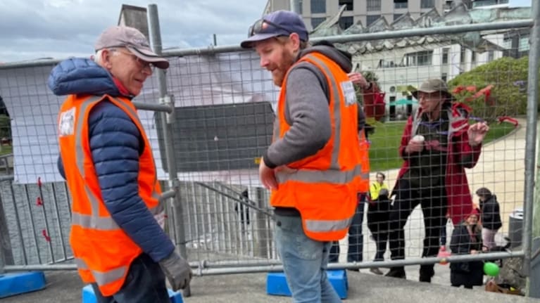 Protestors Alex Gray (left) and Iain Allan (right) preparing to remove one of the fences blocking access to the City to Sea Bridge, on Saturday. Photo: Supplied/ Helene Ritchie