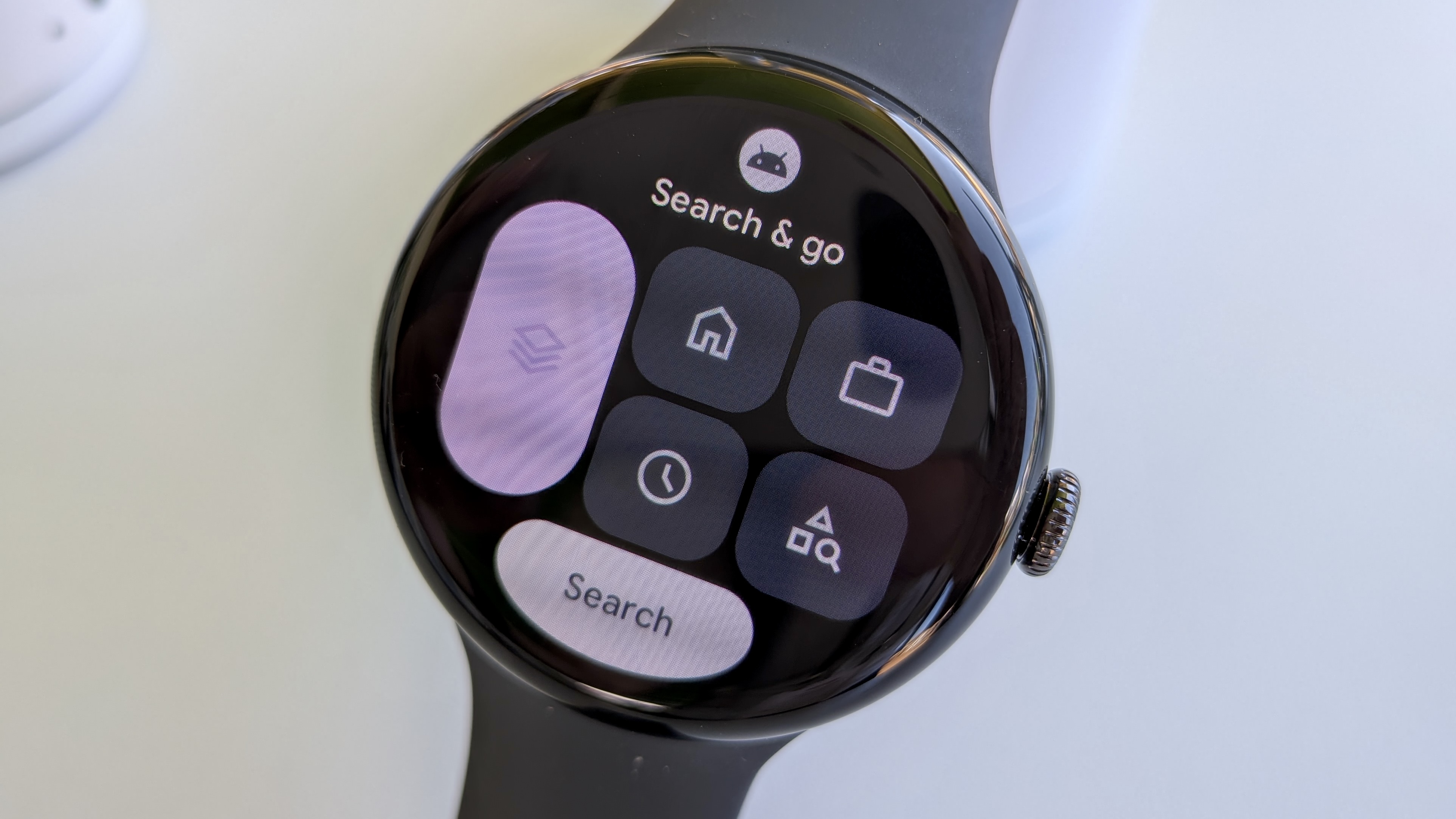 The Search and Go Maps tile on Wear OS 6 on the Pixel Watch 3, showing options like your Home, Work, recents, and favorites, plus a Search button.