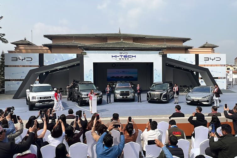 people at trade show in Nepal looking at electric vehicles.