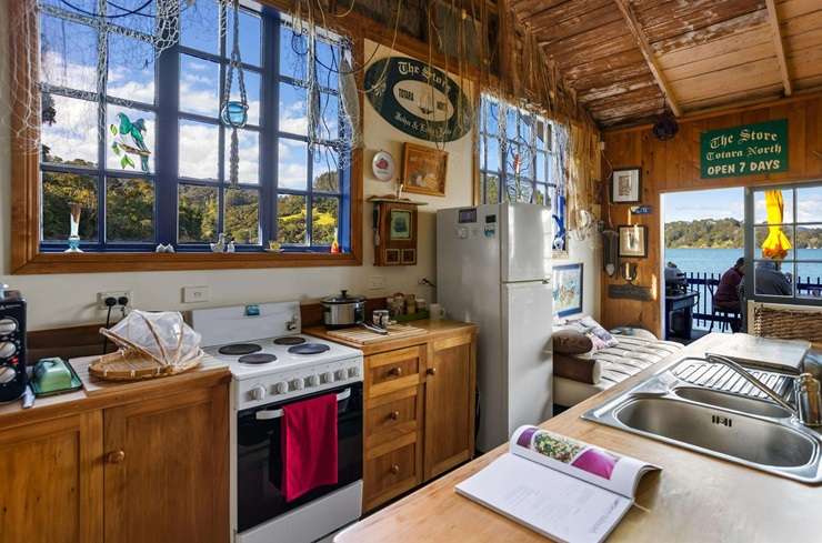 The two-bedroom historic bach at 104 Okura Bay Road, in Totara North, sits over the water on the edge of Whangaroa Harbour. Photo / Supplied