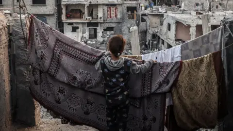 Getty Images A children standing in front of a clothes line, overlooking buildings in Gaza. 