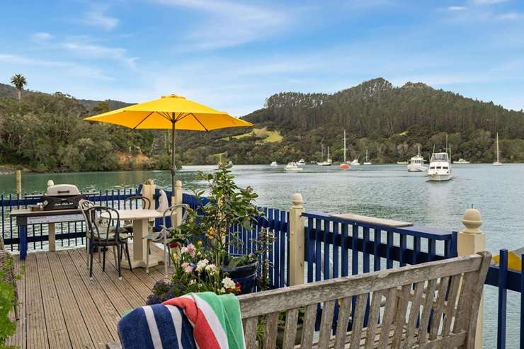 The two-bedroom historic bach at 104 Okura Bay Road, in Totara North, sits over the water on the edge of Whangaroa Harbour. Photo / Supplied