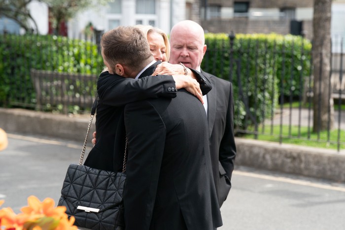 Kathy hugging Ben as Phil looks on in EastEnders