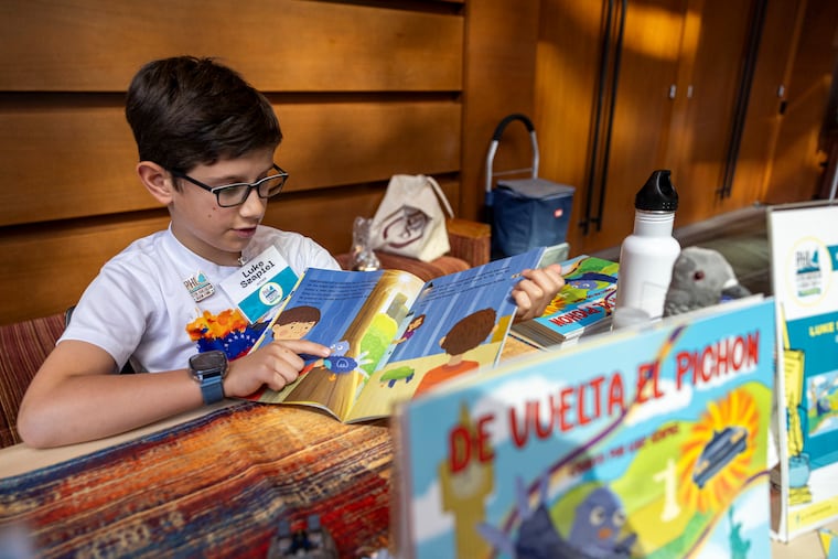 Luke Szapiel, 9, author of "Back to the Pigeon," displays his book at the Latin American Book Fair at the Kimmel Center on Saturday.