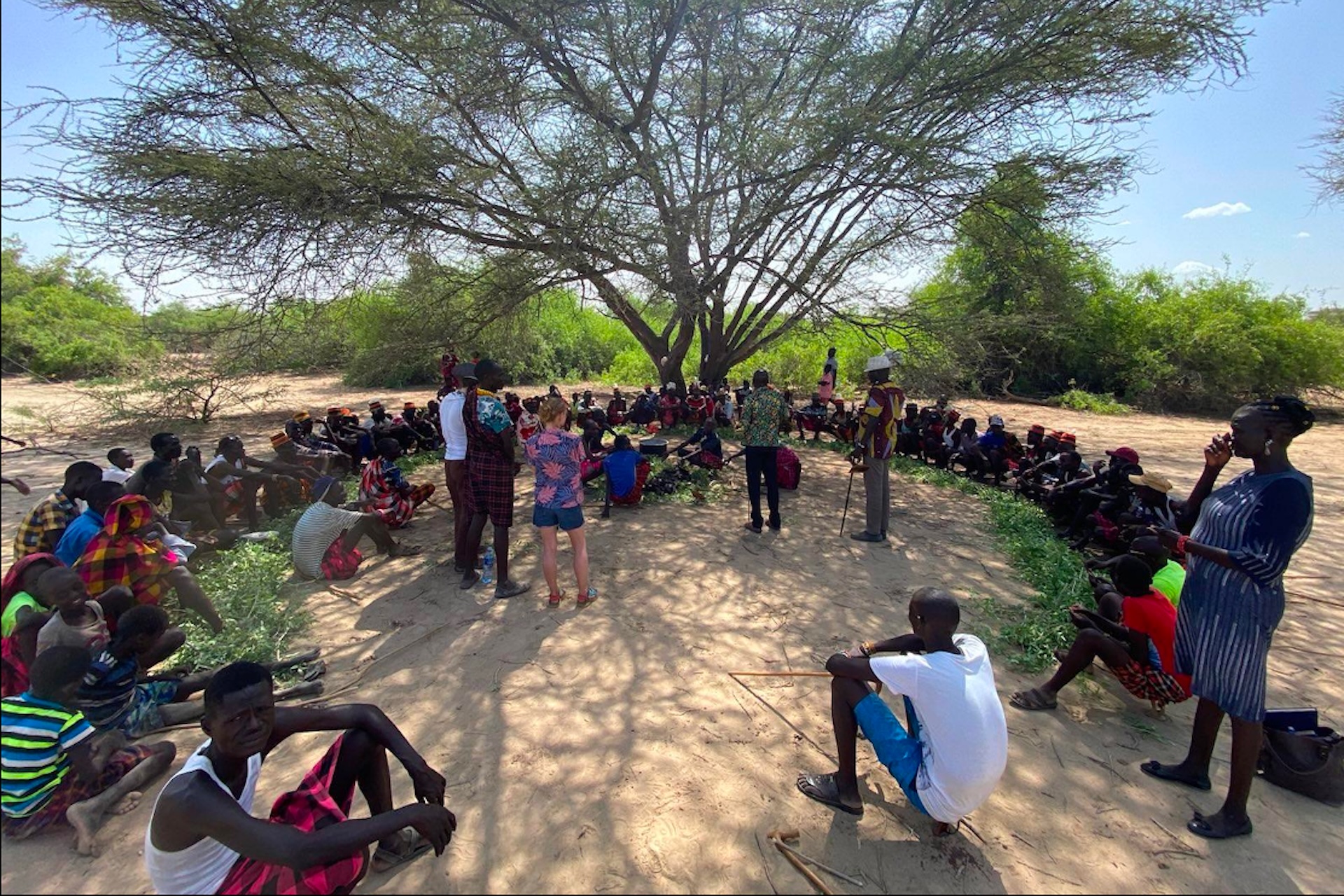 A group of Kenyans gathers in a circle with researchers from UC Berkeley