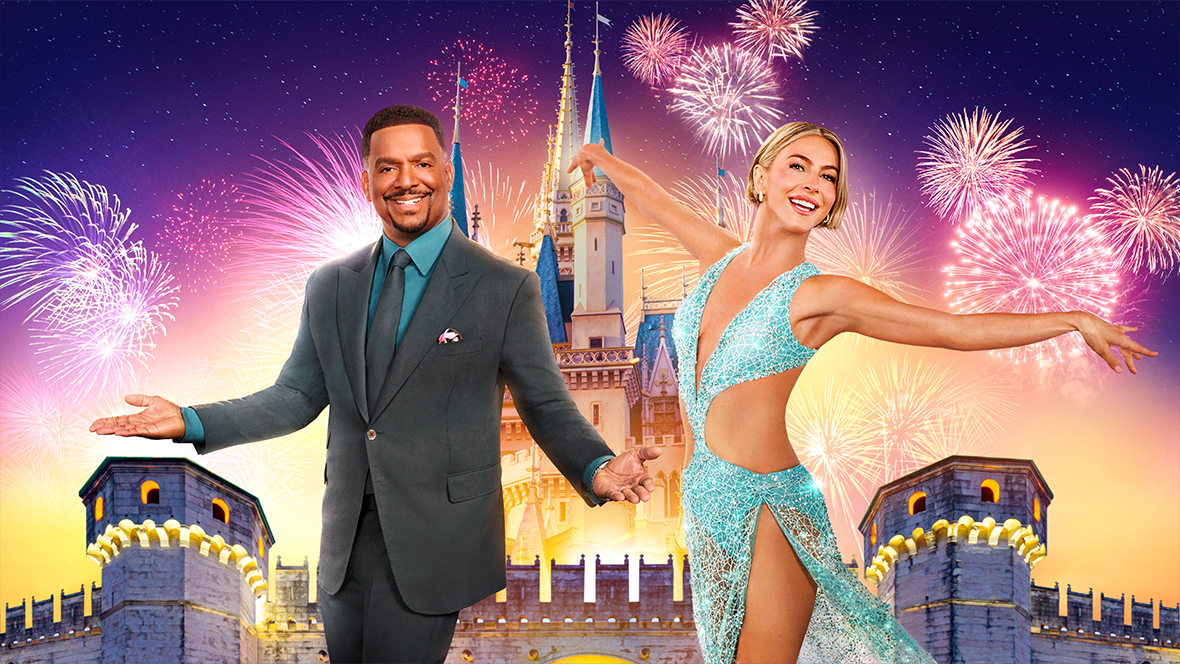 Dancing with the Stars cohosts Alfonso Ribeiro and Julianne Hough are seen in front of an image of a Disney park castle, with fireworks in the background; several fireworks on the right, behind Hough, are shaped like Mickey Mouse.