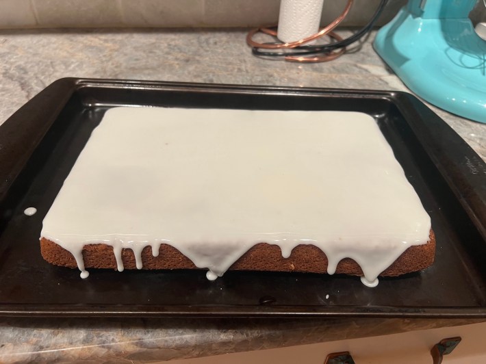 A cake with icing spread all over it.
