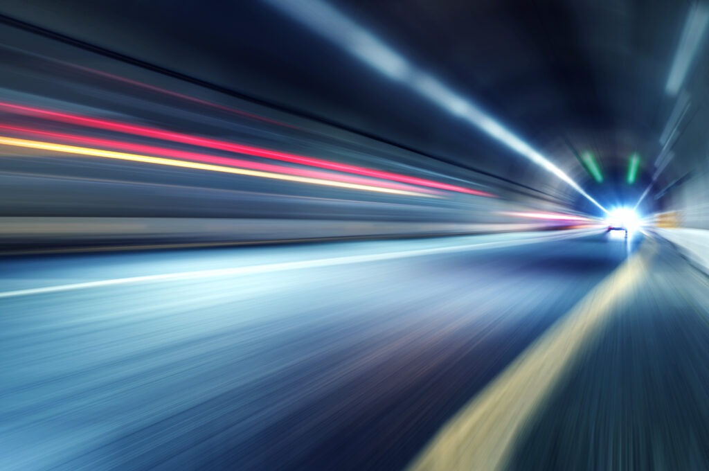 Car lights inside of a tunnel.