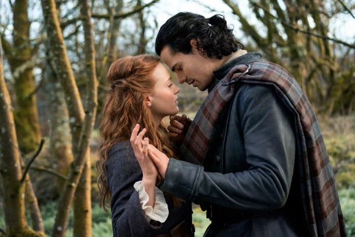 Jamie Roy and Harriet Slater in Outlander: Blood of My Blood holding hands and putting their heads together.