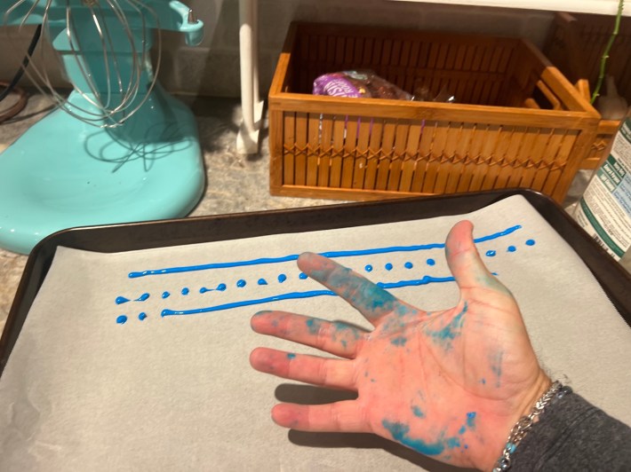 A hand with blue dye all over it.