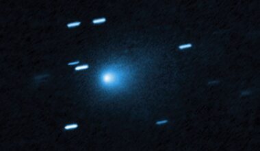A blue ball of light shines between streaks of blueish light from stars in outer space