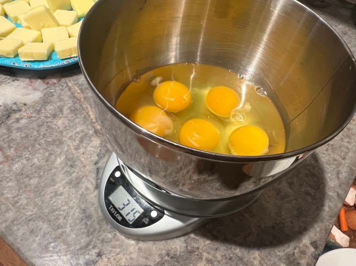 Six eggs in a metal bowl, weighing 315 grams.
