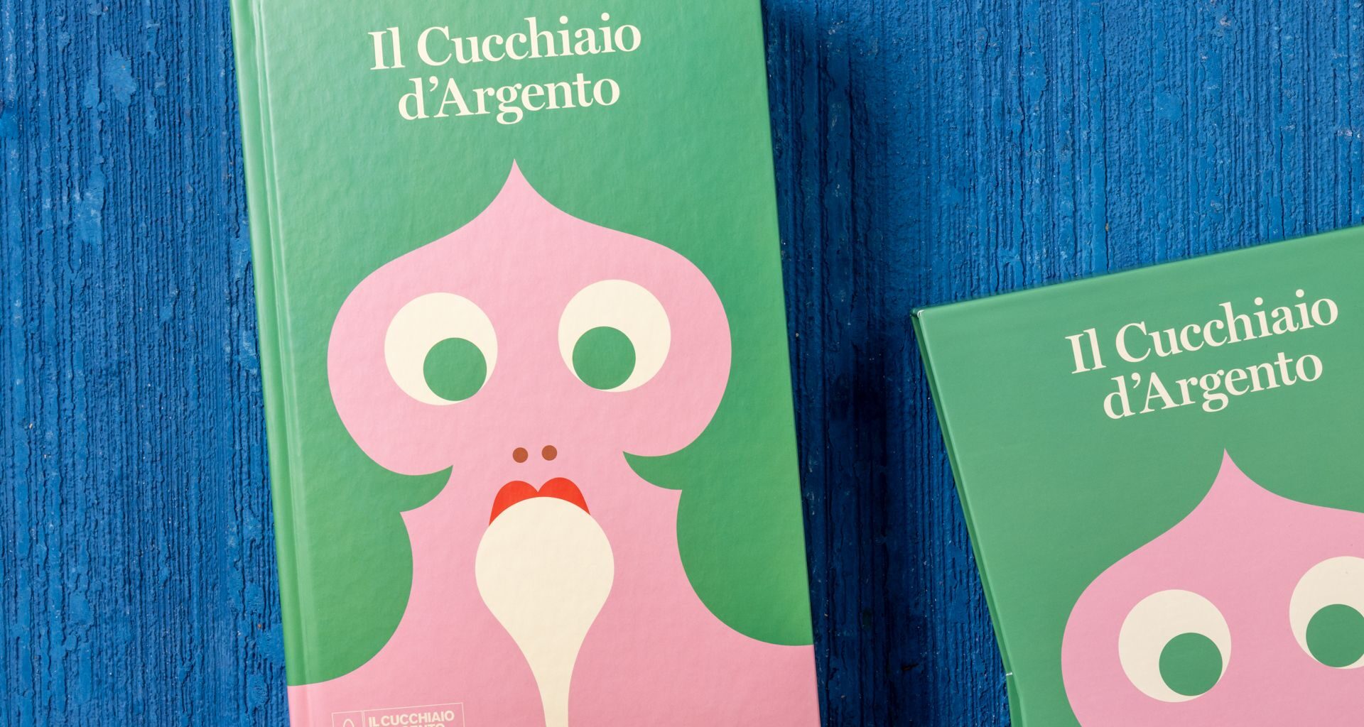 Book cover: il Cucchiaio d'Argento, featuring an illustration by Olimpia Zagnoli with a person's face with green hair licking a white spoon