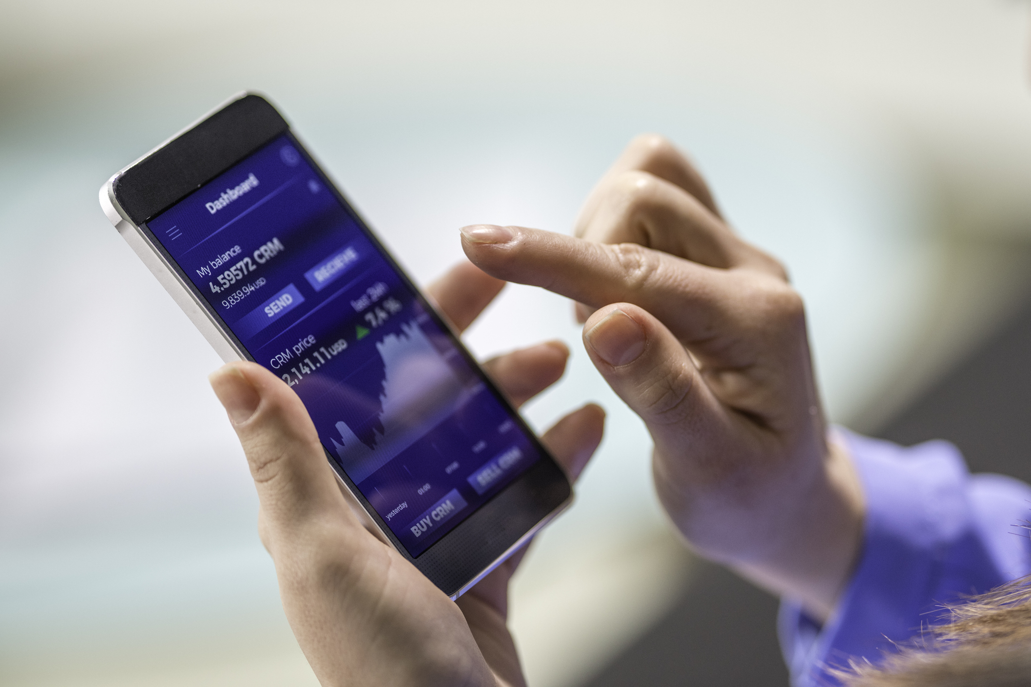 A person submitting a stock order on a mobile device.