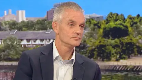 BBC Tim Davie, wearing a suit, sitting in the BBC Breakfast studio