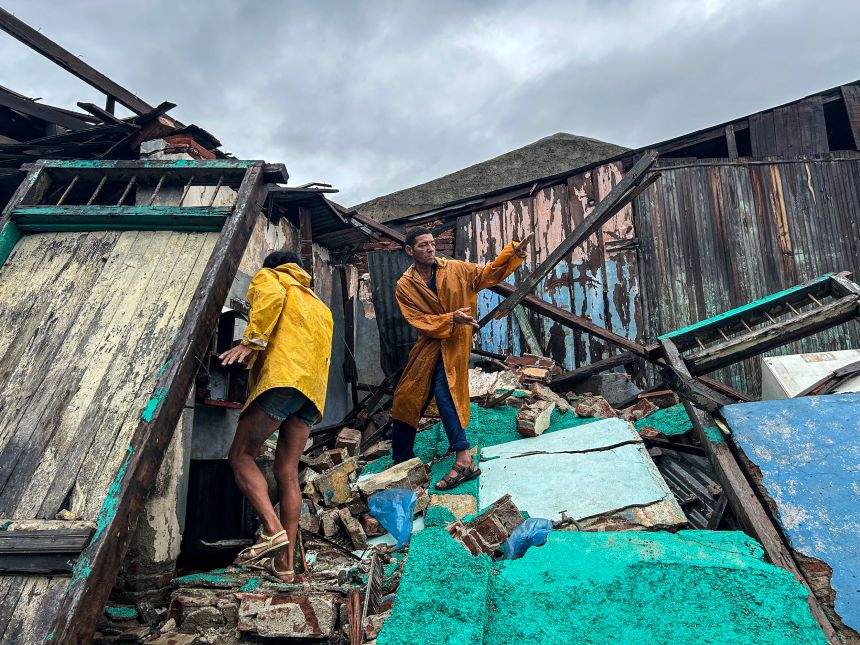 A family salvages belongings from the rubble of their home in Santiago de Cuba, Cuba, on Wednesday.
