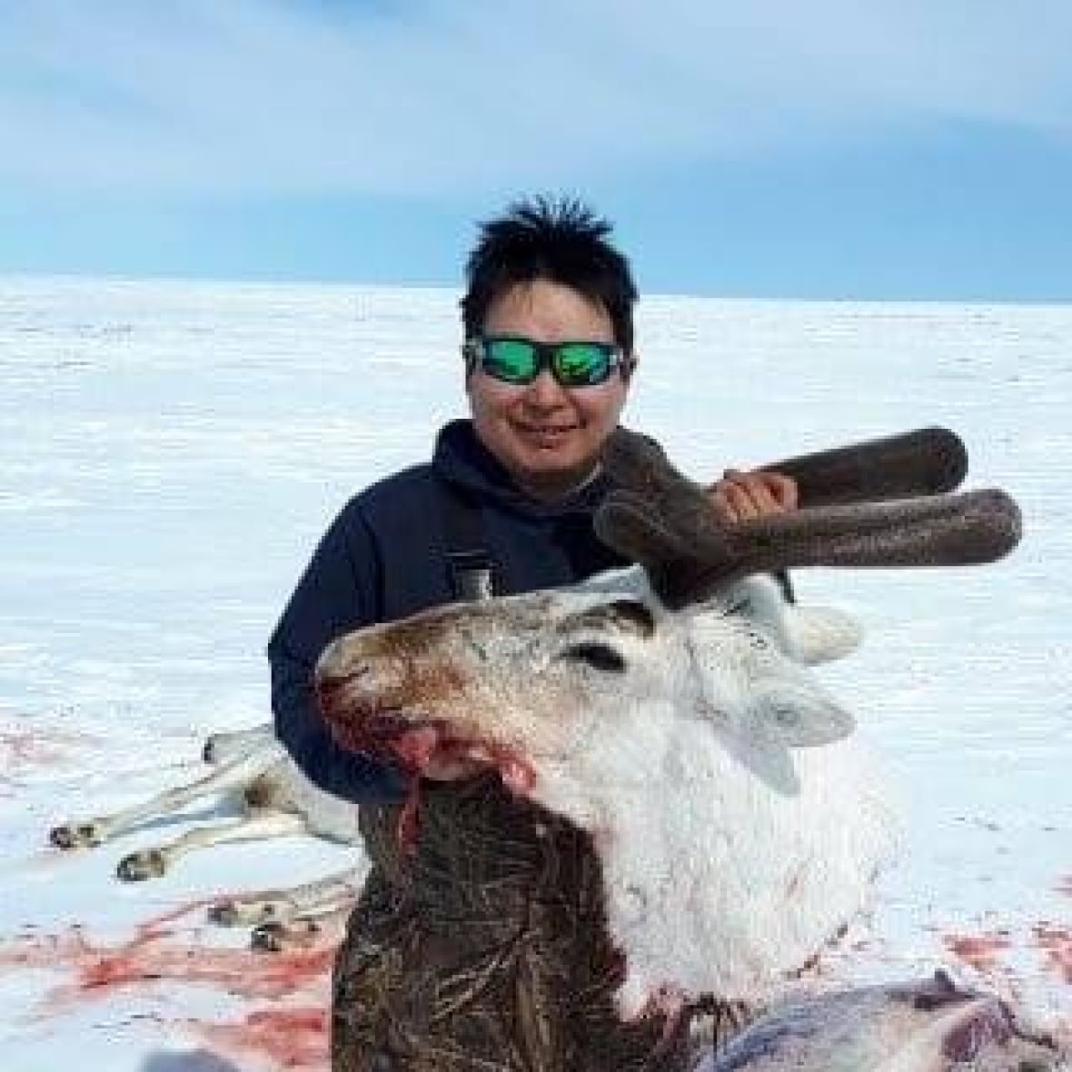 man holds head of animal carcass