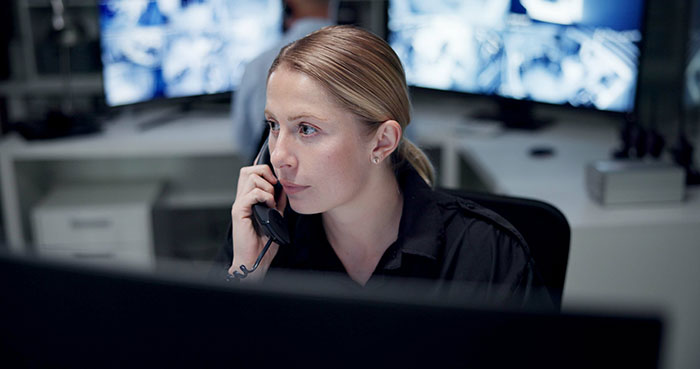 Woman in a control room speaking on the phone, focused on correcting self-diagnosed medical assumptions.
