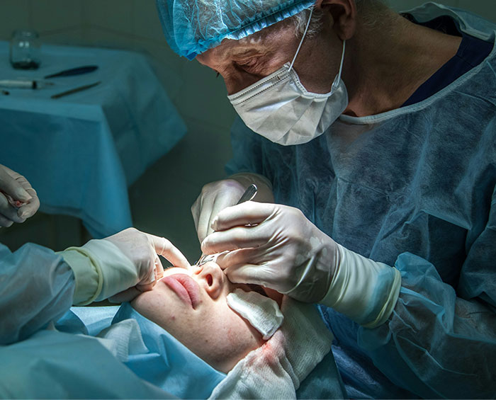 Surgeon performing delicate facial surgery in an operating room, highlighting bone-chilling and hilarious surgery stories.