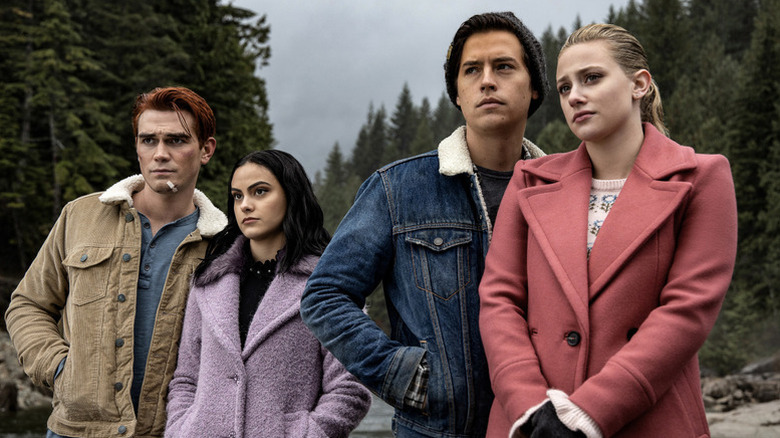 Archie Andrews (KJ Apa), Veronica Lodge (Camila Mendes), Jughead Jones (Cole Sprouse), and Betty Cooper (Lili Reinhart) stand in a forest on Riverdale