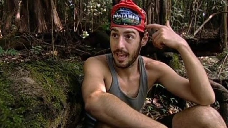 Rob scratching his head talking in the jungle on Survivor