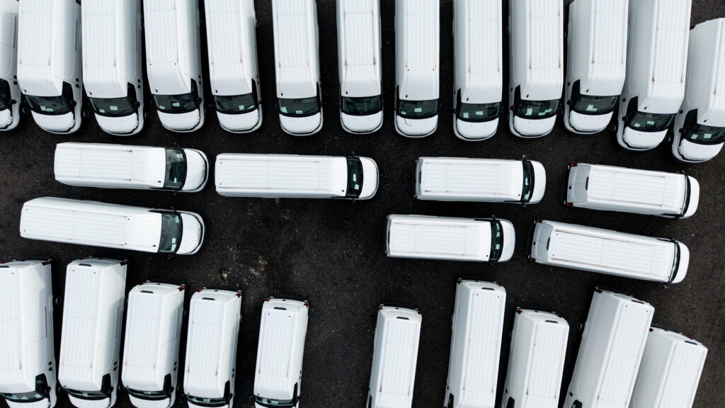 Aerial view directly above a stockpile of new white vans ready for export
