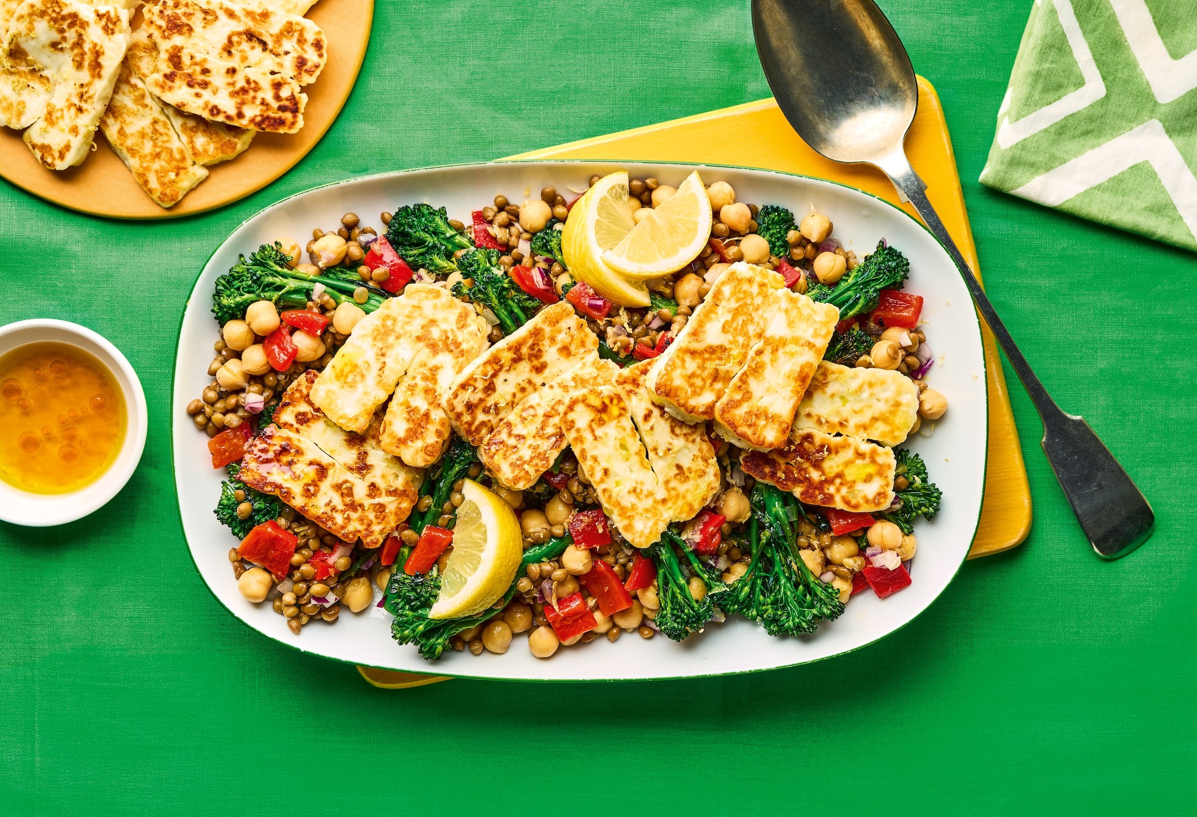 Halloumi cheese on a bed of lentils, chickpeas, and broccoli.