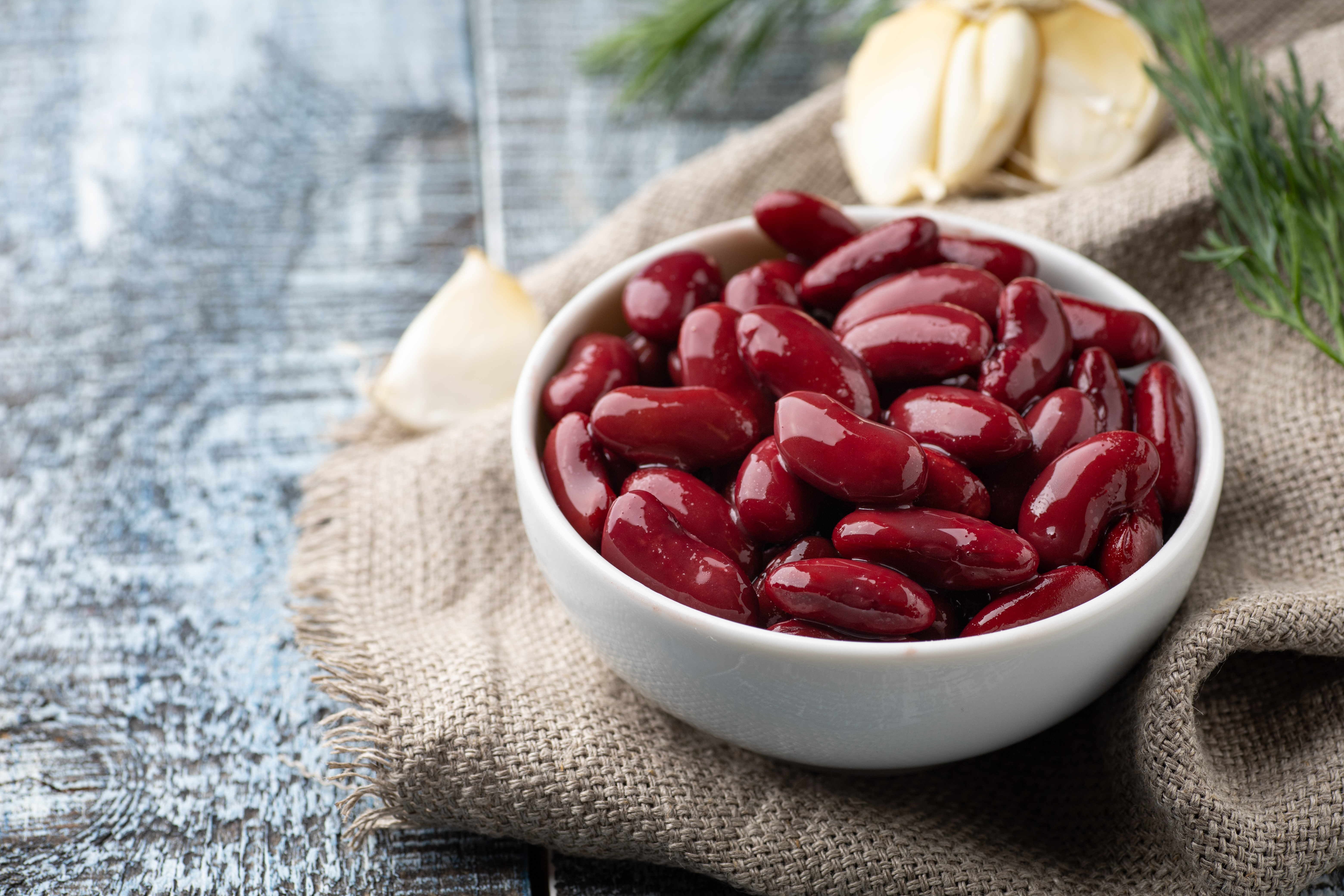Red kidney beans in a white bowl on a table.