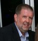 Simon Stock, nephew of the late Doreen Stock, wearing a suit jacket and collared shirt.