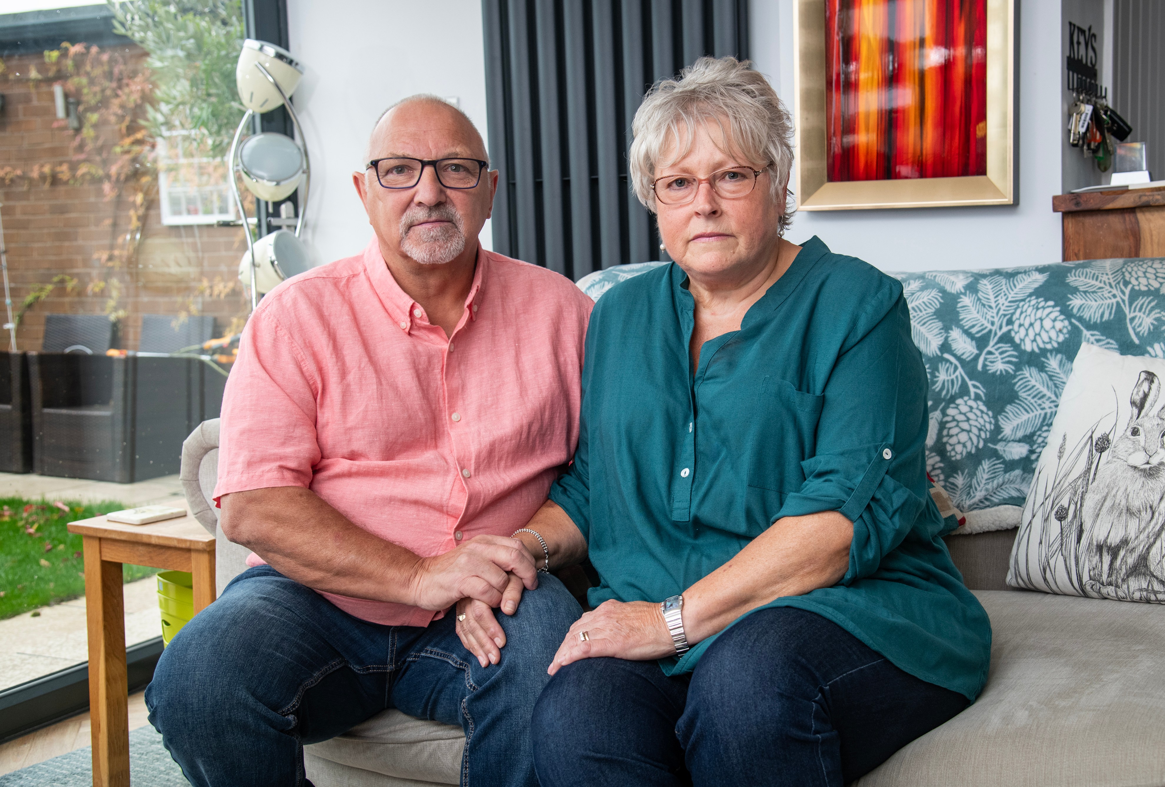 Reg and Geraldine Smith, a retired couple, sitting on a couch.