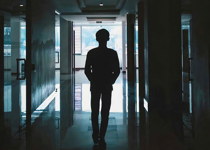 Silhouette of a person walking through a dimly lit hallway inside a psychiatric institution, reflecting an unforgettable experience.