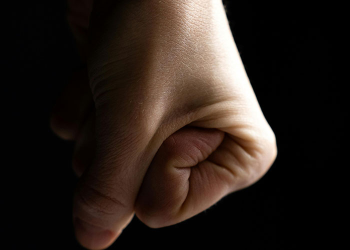 Close-up of a clenched fist symbolizing the intense moments psychiatric institution workers experienced on the job.