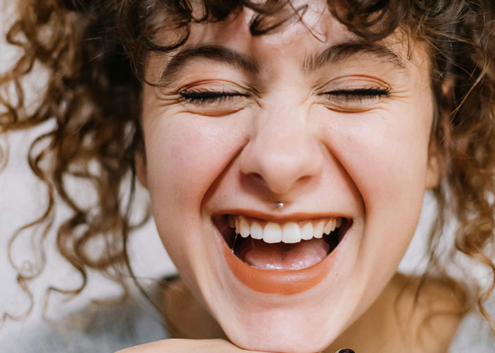 Close-up of a person smiling with eyes closed, capturing an unforgettable moment in a psychiatric institution setting.