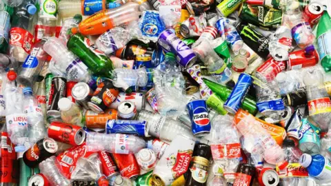 Getty Images A colourful image of a large and varied collection of bottles and cans, hopefully ready for recycling - they include a range of recognisable brands of both soft and alcoholic drinks as well as water and sports drinks.