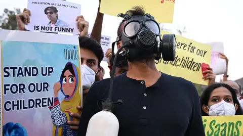 Getty Images Demonstrators wearing masks and holding posters and placards during a protest demanding the government to take action to reduce air pollution in Delhi on 9 November