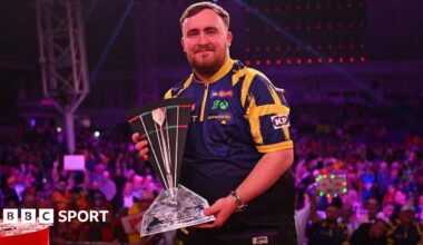 Luke Littler poses with the trophy following the final with Nathan Aspinall