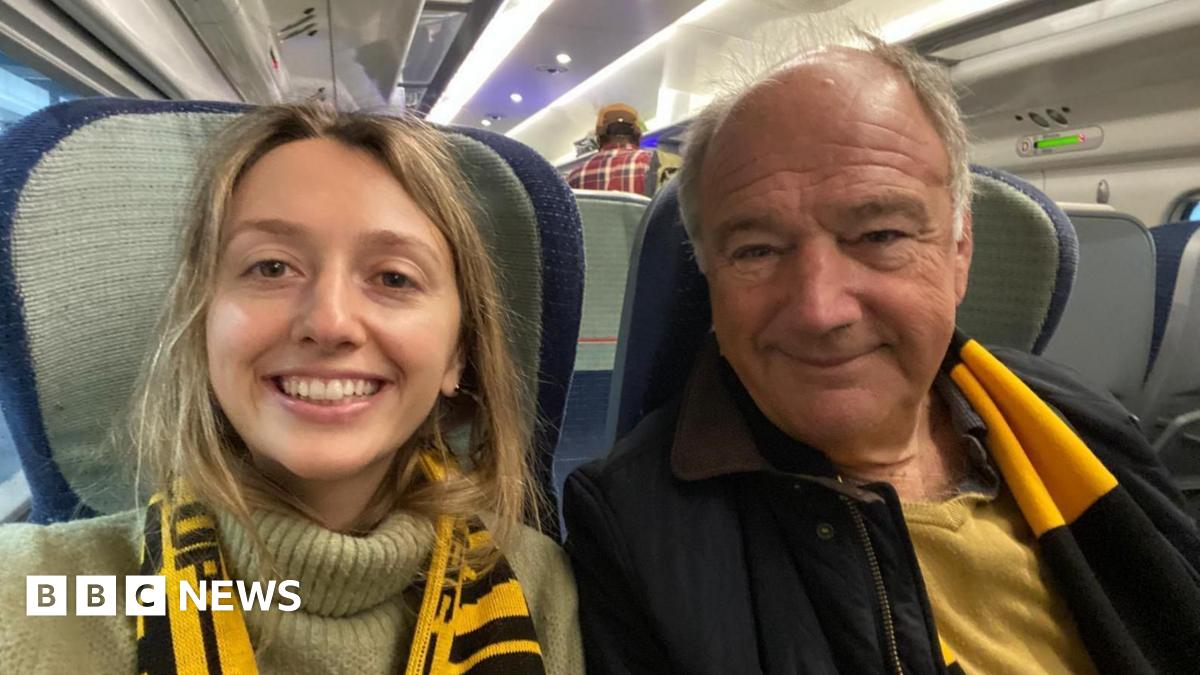 Kate with her father Mark on the train on their way to a Wolverhampton Wanderers football match wearing the merch scarf