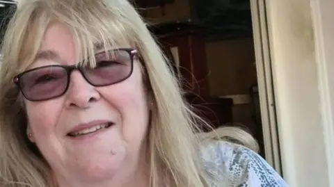 Handout Elaine Lawrence, 71, who has shoulder-length blonde hair, is wearing tinted glasses and a blue and white blouse, smiles into the camera