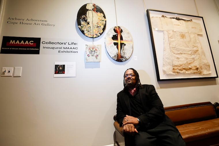 Art collector William Skeet Jiggetts sits near artwork he has collected during the Museum of African American Art Collections inaugural exhibit at the Awbury Arboretum in East Germantown.