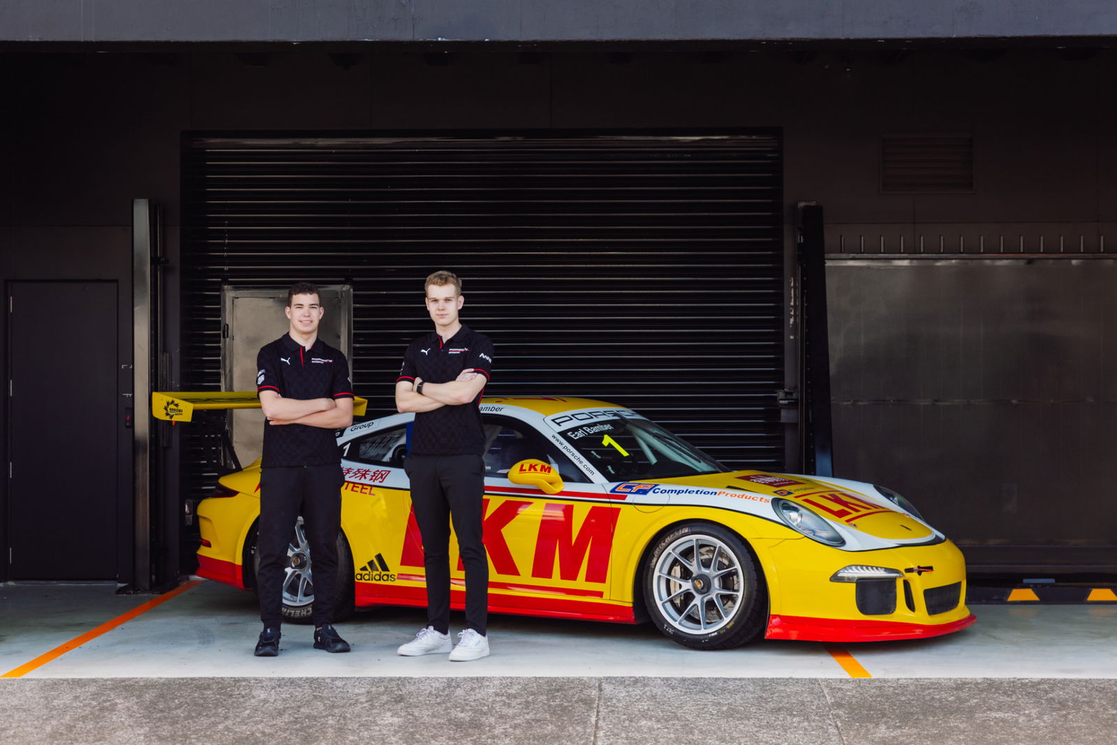 Tom Bewley (left) with Marco Giltrap and Earl Bamber's 2013 Porsche Carrera Cup Asia race-winning Porsche 911 GT3 Cup car.