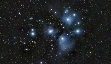 Several bright blue stars surrounded with glowing blue wisps, with many fainter stars in the background.