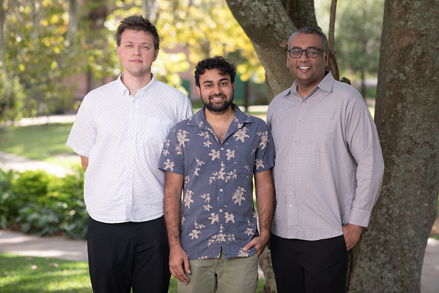 Three men standing outside. They are, from left, researchers Cyprian Lewandowski, Aman Kumar and Hitesh Changlani.