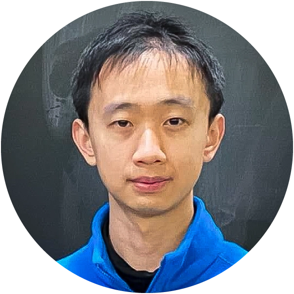 Man in a blue fleece standing in front of a chalkboard.