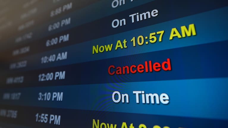 A flight is listed as cancelled on a display at San Diego International Airport.