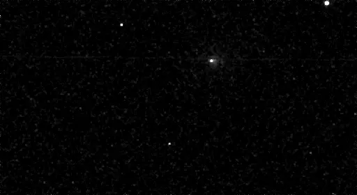 A fuzzy white object moving against the background stars.
