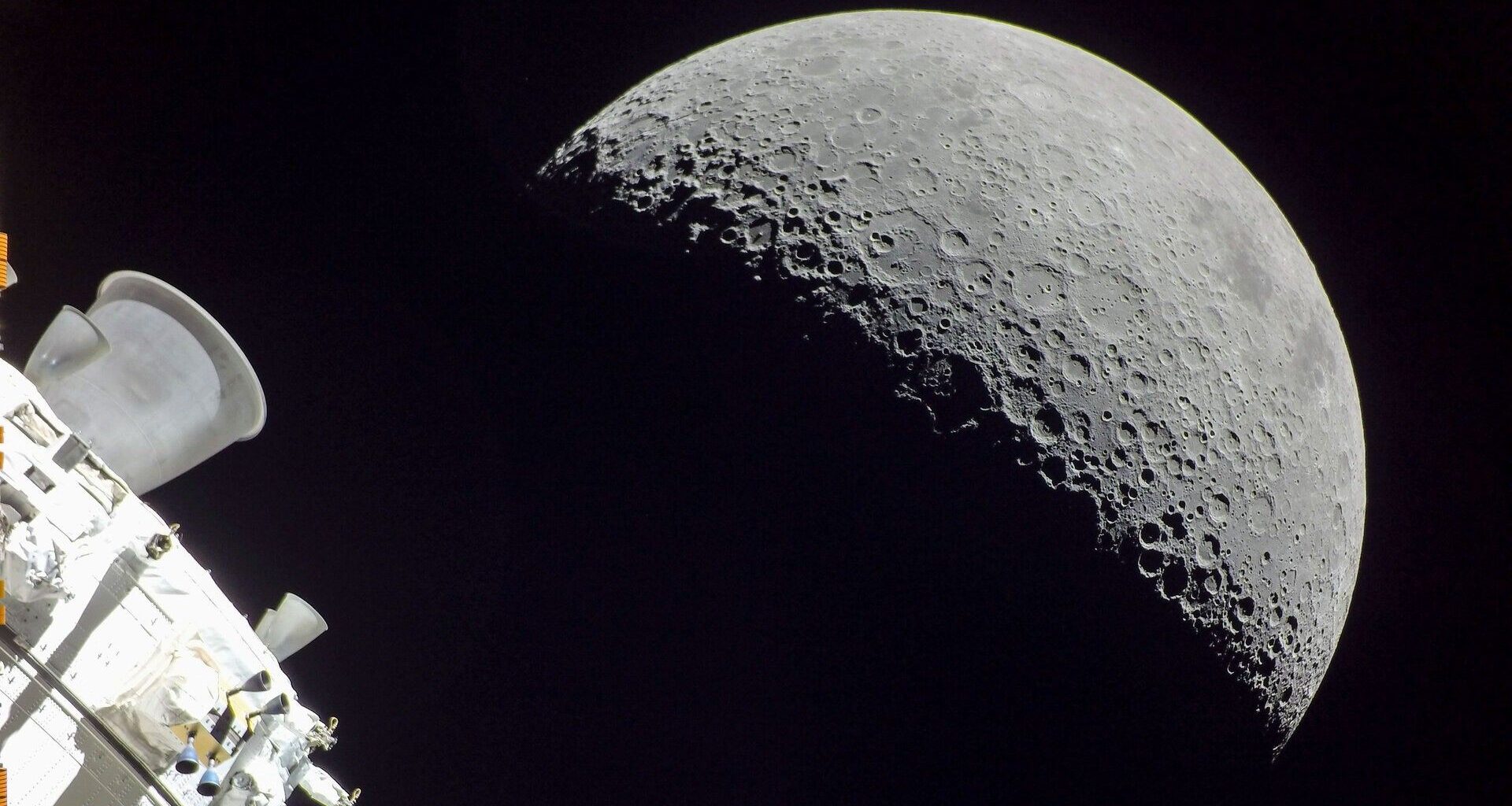 a half-lit moon seen behind the cone-shaped nozzle of a spacecraft engine
