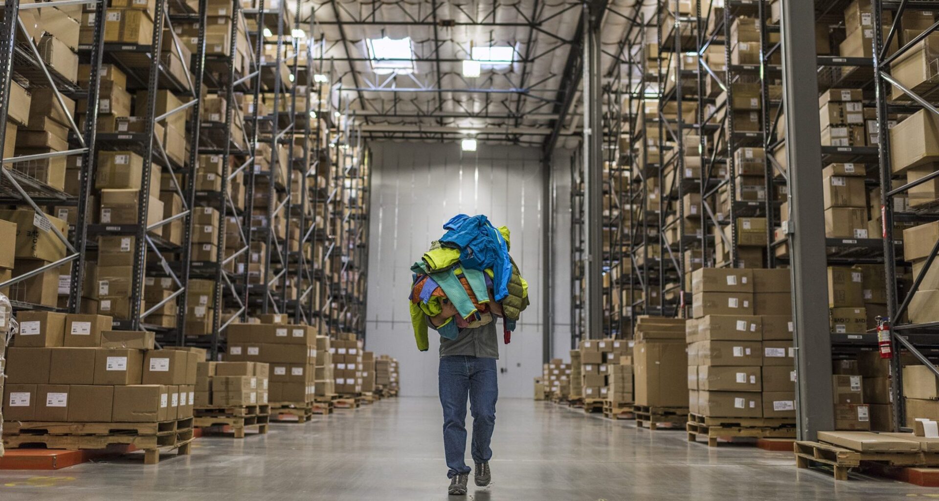 Warehouse with boxes and person carrying garments